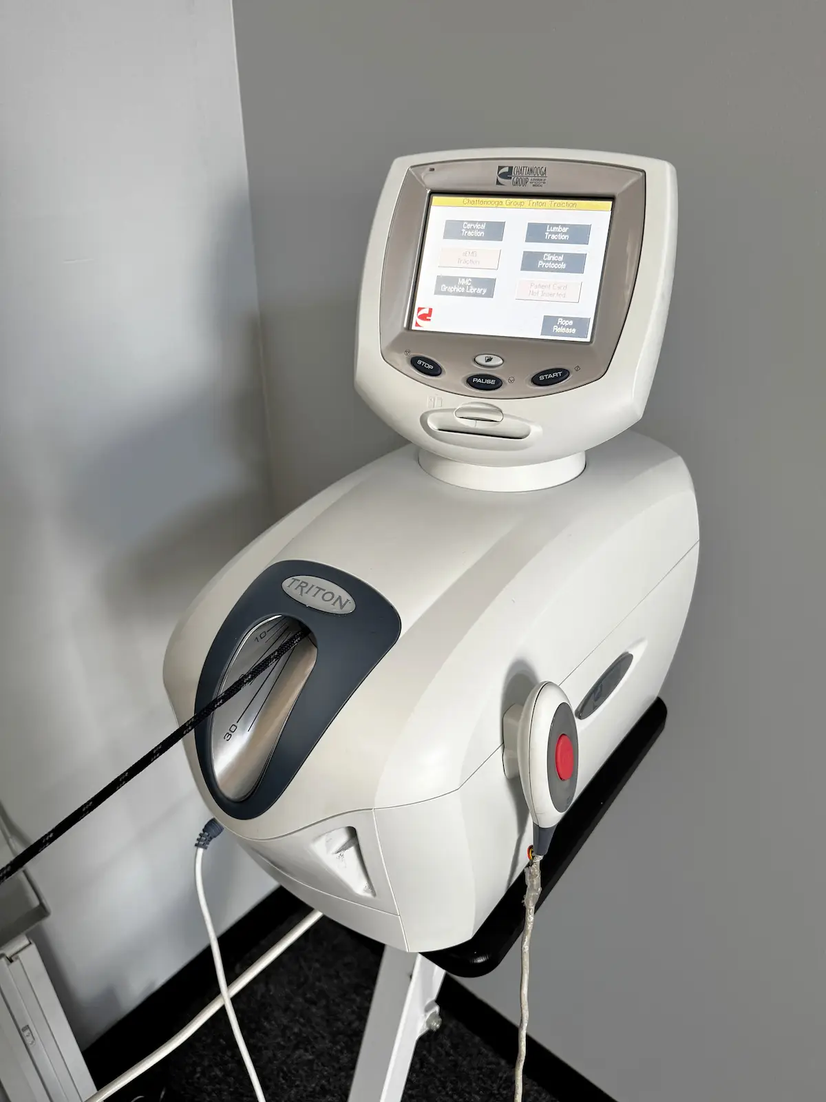 A Chattanooga Group Triton Traction machine, a white medical device with a digital screen and control buttons.